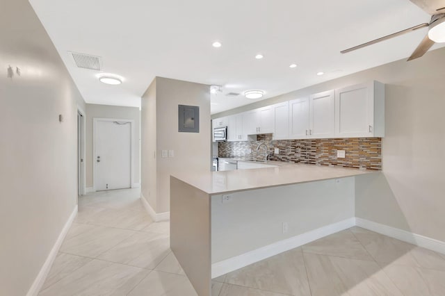 1131 Violet Ter Unit 104, Delray Beach, FL 33445 - kitchen with light countertops, stainless steel microwave, decorative backsplash, a peninsula, and recessed lighting