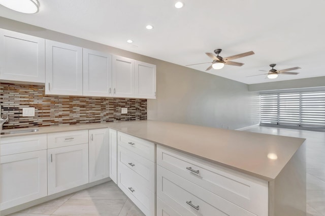 1131 Violet Ter Unit 104, Delray Beach, FL 33445 - kitchen featuring a peninsula, tasteful backsplash, a ceiling fan, white cabinetry, and recessed lighting