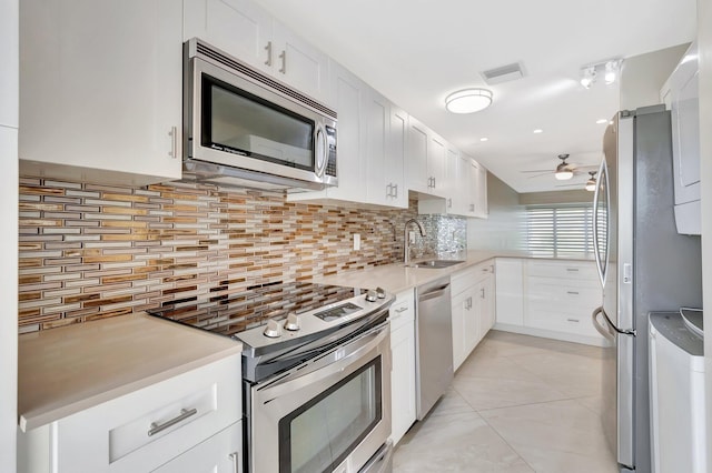 1131 Violet Ter Unit 104, Delray Beach, FL 33445 - kitchen with stainless steel appliances, a sink, a ceiling fan, and decorative backsplash