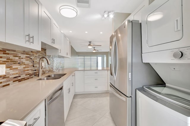 1131 Violet Ter Unit 104, Delray Beach, FL 33445 - kitchen featuring appliances with stainless steel finishes, estacked washer and dryer, a sink, a ceiling fan, and white cabinets