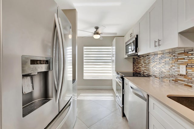 1131 Violet Ter Unit 104, Delray Beach, FL 33445 - kitchen featuring appliances with stainless steel finishes, decorative backsplash, a ceiling fan, white cabinetry, and light countertops