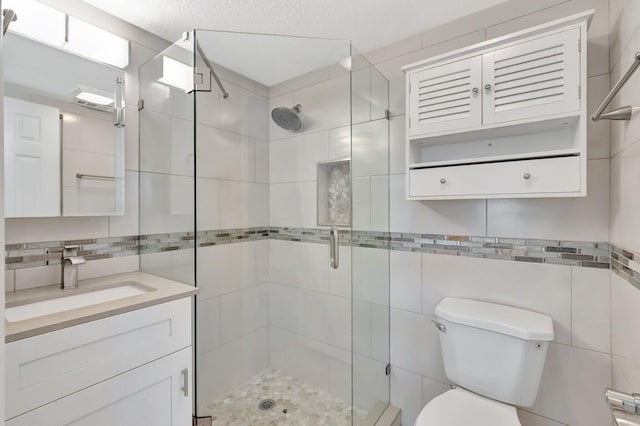1131 Violet Ter Unit 104, Delray Beach, FL 33445 - bathroom featuring tile walls, a shower stall, toilet, and vanity