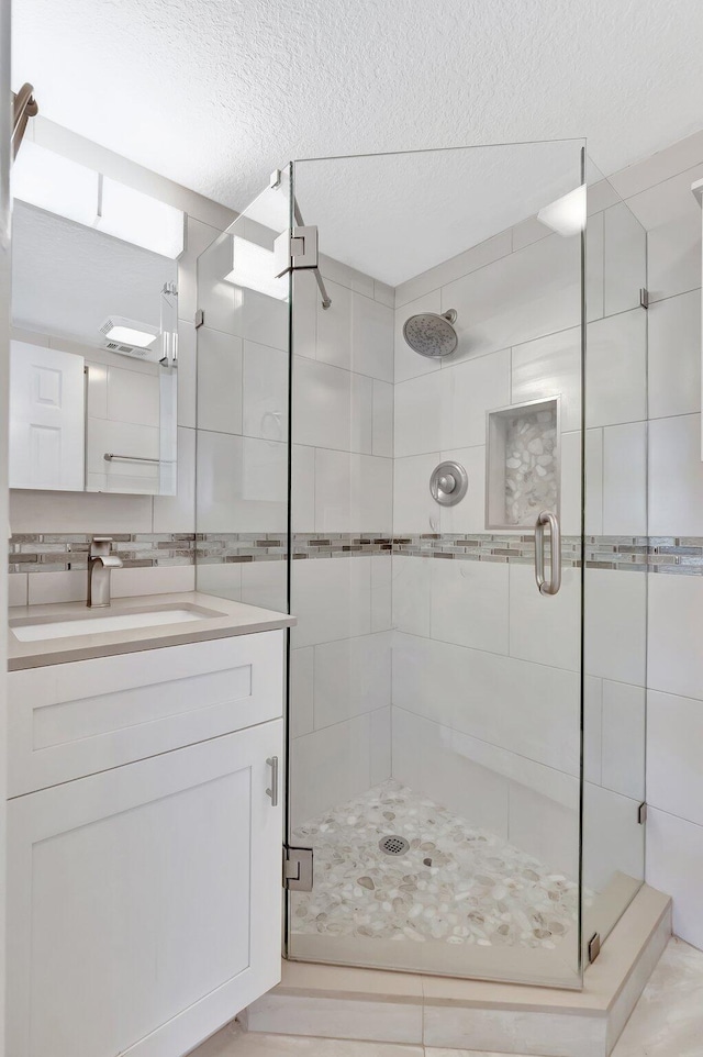 1131 Violet Ter Unit 104, Delray Beach, FL 33445 - full bathroom with a textured ceiling, a shower stall, and vanity