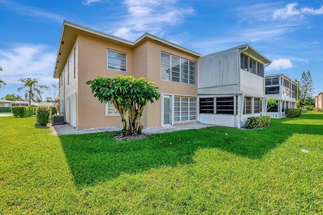 1131 Violet Ter Unit 104, Delray Beach, FL 33445 - rear view of property with a yard, stucco siding, and central AC