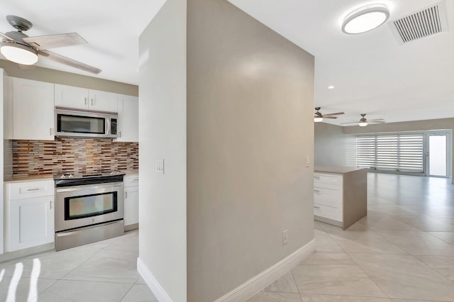 1131 Violet Ter Unit 104, Delray Beach, FL 33445 - kitchen featuring appliances with stainless steel finishes, a ceiling fan, backsplash, white cabinetry, and recessed lighting