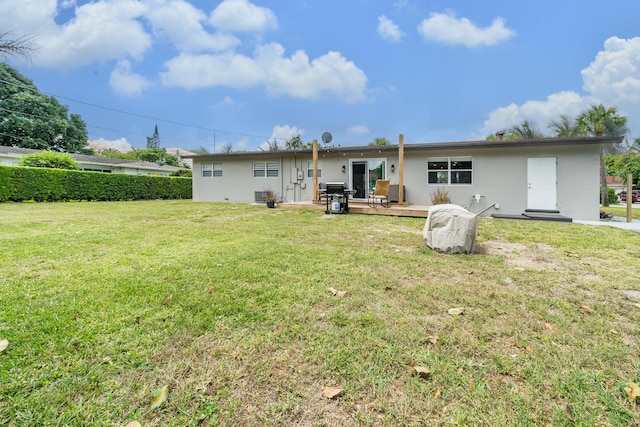 back of property with a lawn and stucco siding