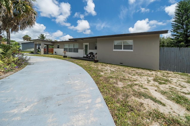 single story home with stucco siding, fence, and concrete driveway