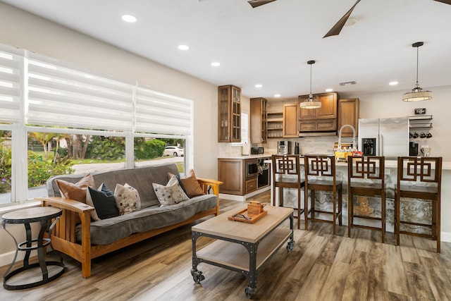 living room with light wood-style floors, recessed lighting, and baseboards