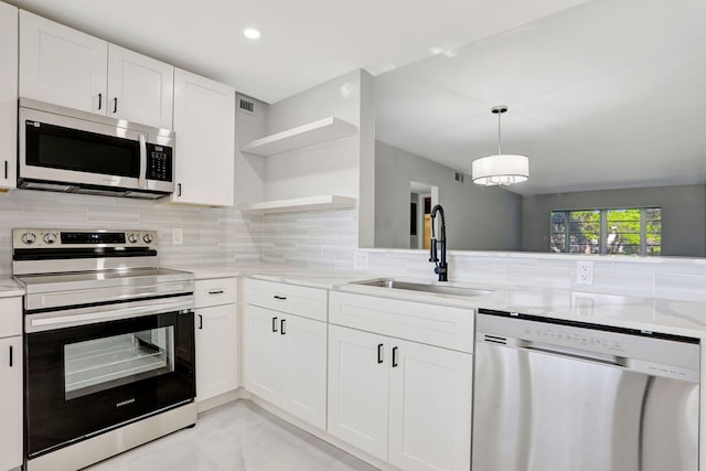 2202 Lucaya Bnd Unit G2, Coconut Creek, FL 33066 - kitchen with appliances with stainless steel finishes, a sink, open shelves, light marble finish flooring, and decorative backsplash