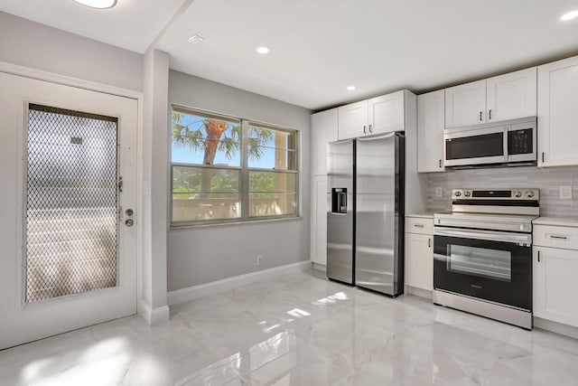2202 Lucaya Bnd Unit G2, Coconut Creek, FL 33066 - kitchen with appliances with stainless steel finishes, white cabinetry, baseboards, light countertops, and recessed lighting