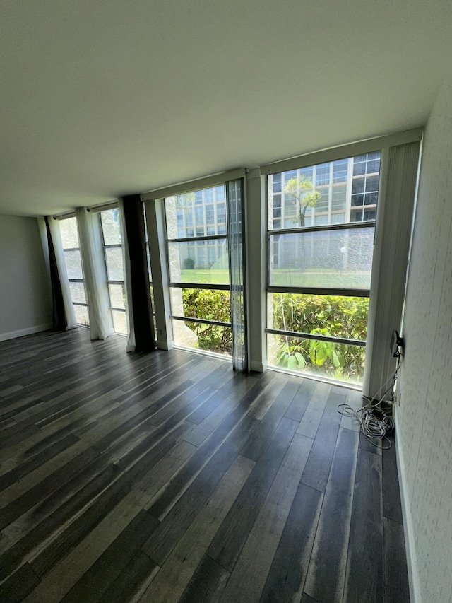 851 Three Islands Blvd Unit 102, Hallandale Beach, FL 33009 - unfurnished room with dark wood finished floors, plenty of natural light, and a wall of windows