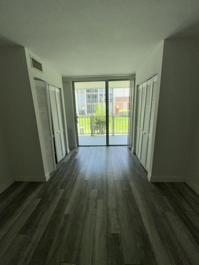 851 Three Islands Blvd Unit 102, Hallandale Beach, FL 33009 - unfurnished bedroom featuring access to exterior, dark wood finished floors, and baseboards