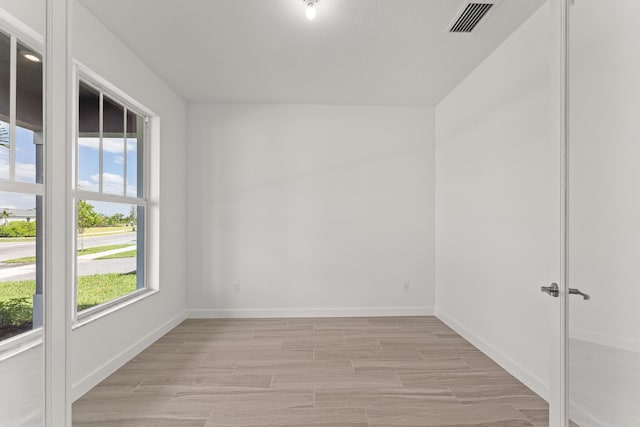 13461 SW Bally Dr, Port Saint Lucie, FL 34987 - empty room featuring healthy amount of natural light, baseboards, and light wood finished floors