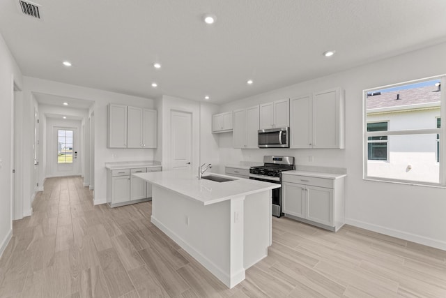 13461 SW Bally Dr, Port Saint Lucie, FL 34987 - kitchen featuring appliances with stainless steel finishes, a sink, an island with sink, recessed lighting, and baseboards