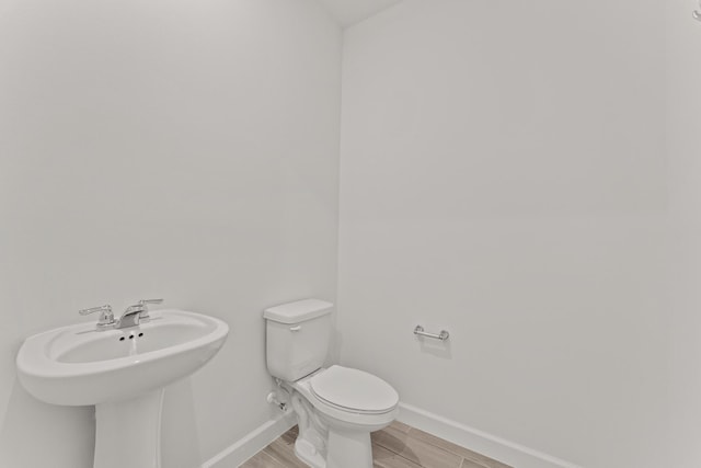 13461 SW Bally Dr, Port Saint Lucie, FL 34987 - bathroom featuring toilet, baseboards, a sink, and wood finished floors