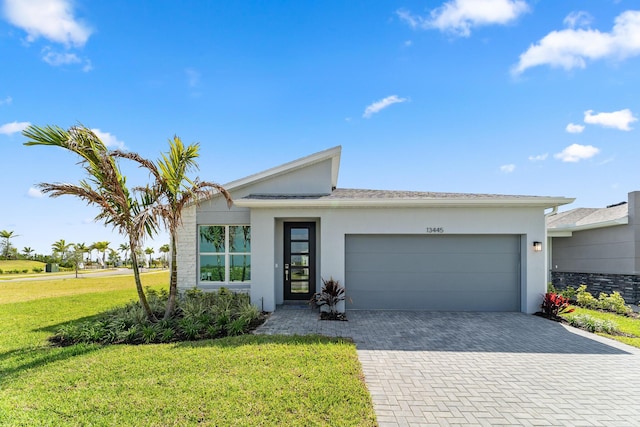 13445 SW Bally Dr, Port Saint Lucie, FL 34987 - view of front facade with stucco siding, an attached garage, a front lawn, and decorative driveway