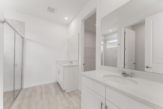 13445 SW Bally Dr, Port Saint Lucie, FL 34987 - full bathroom with a shower stall, two vanities, wood finished floors, recessed lighting, and a walk in closet
