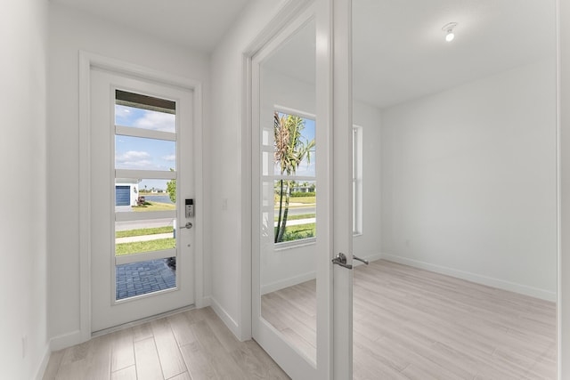 13445 SW Bally Dr, Port Saint Lucie, FL 34987 - doorway to outside with light wood-style flooring and baseboards
