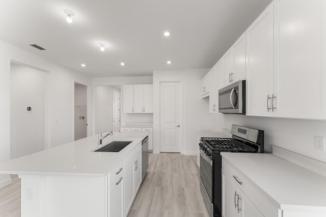 13445 SW Bally Dr, Port Saint Lucie, FL 34987 - kitchen featuring stainless steel appliances, a sink, light wood-type flooring, recessed lighting, and an island with sink