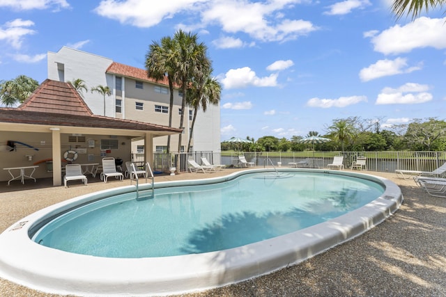 community pool featuring fence and a patio