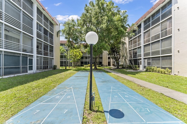view of home's community with a yard and shuffleboard