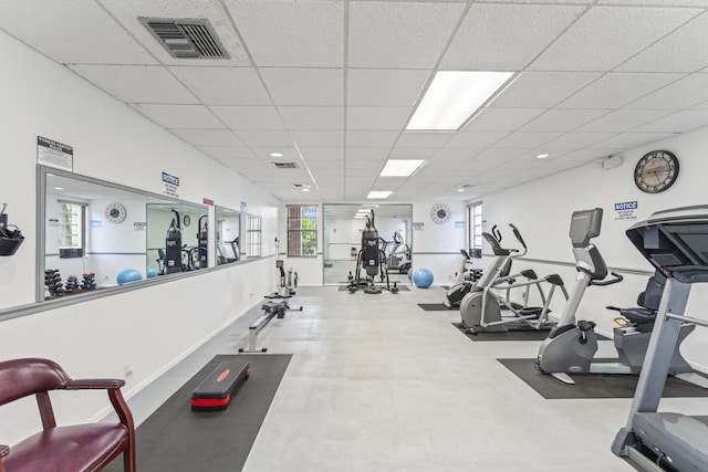 workout area featuring a drop ceiling and baseboards