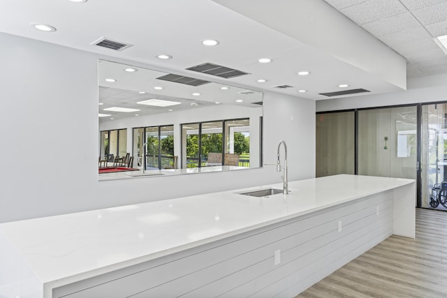 kitchen featuring a sink, light wood-type flooring, recessed lighting, light countertops, and modern cabinets