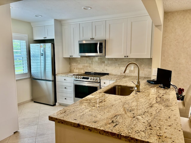 21728 Arriba Real A 34-A, Boca Raton, FL 33433 - kitchen featuring appliances with stainless steel finishes, a sink, light stone countertops, tasteful backsplash, and white cabinets