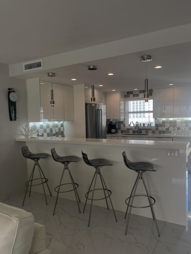 215 N Birch Rd Unit 8C, Fort Lauderdale, FL 33304 - kitchen with high end fridge, a sink, light marble finish flooring, a kitchen breakfast bar, and recessed lighting