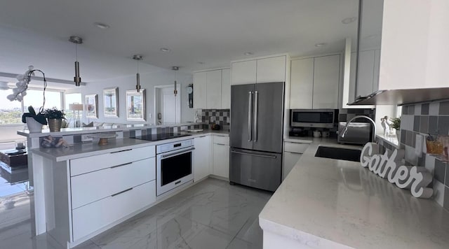 215 N Birch Rd Unit 8C, Fort Lauderdale, FL 33304 - kitchen with appliances with stainless steel finishes, a peninsula, modern cabinets, decorative backsplash, and a sink