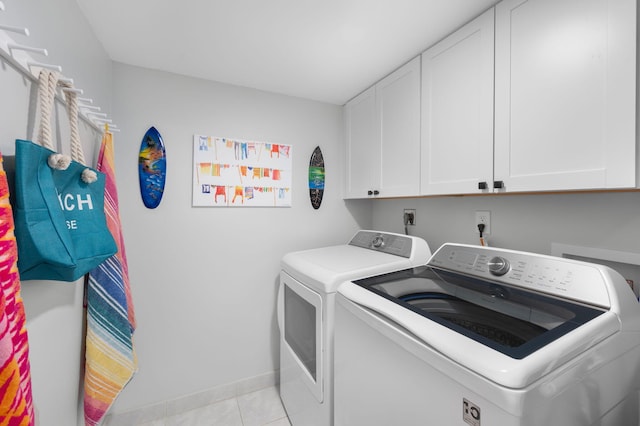 laundry area featuring independent washer and dryer, cabinet space, baseboards, and light tile patterned flooring