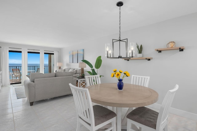 dining room with a chandelier, light tile patterned floors, and baseboards