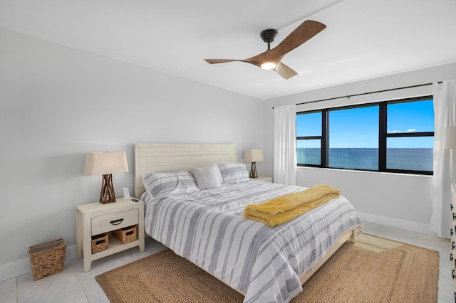 tiled bedroom featuring a ceiling fan and baseboards