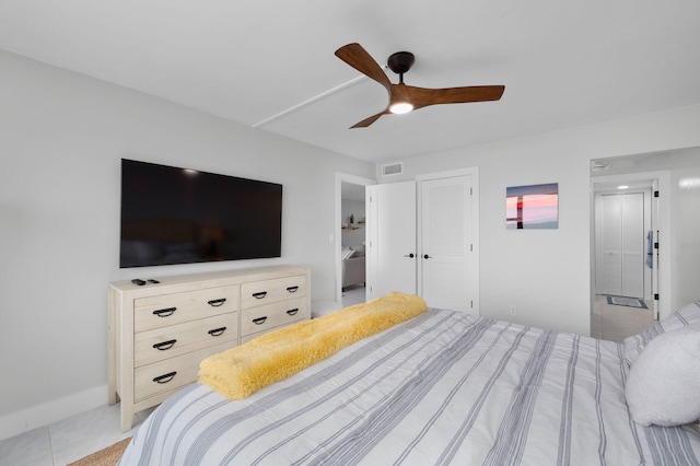 bedroom with light tile patterned flooring, ceiling fan, and a closet