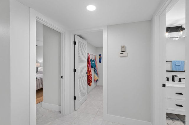hallway with light tile patterned floors, baseboards, and recessed lighting
