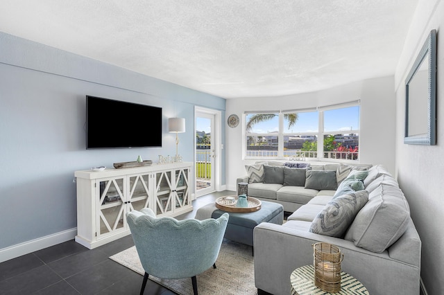 1536 SE 15th Ct Unit 107, Deerfield Beach, FL 33441 - living area with plenty of natural light, baseboards, a textured ceiling, and dark tile patterned flooring