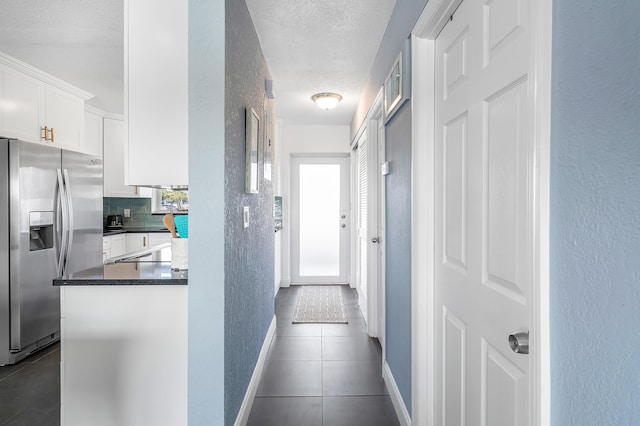 1536 SE 15th Ct Unit 107, Deerfield Beach, FL 33441 - hall with dark tile patterned flooring, baseboards, a textured wall, and a textured ceiling