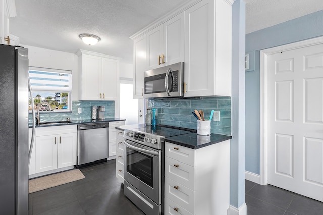 1536 SE 15th Ct Unit 107, Deerfield Beach, FL 33441 - kitchen with stainless steel appliances, a sink, dark tile patterned floors, dark countertops, and a textured ceiling