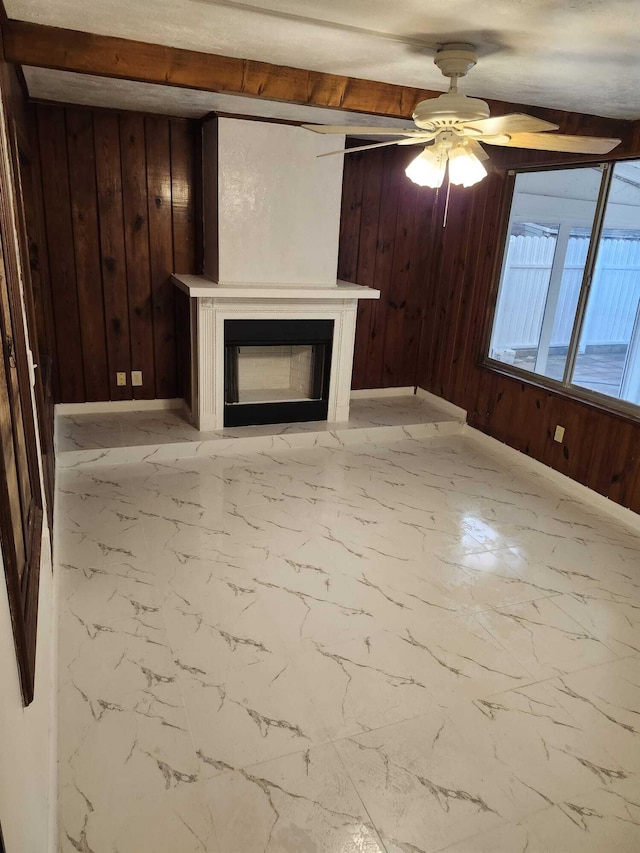 119 S Price St S, Lake Worth, FL 33461 - unfurnished living room featuring wood walls, a fireplace, marble look tile flooring, ceiling fan, and baseboards
