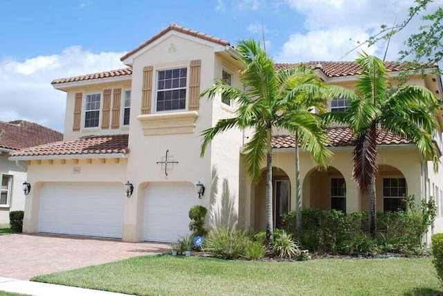 461 Cresta Cir, West Palm Beach, FL 33413 - mediterranean / spanish-style home with a tiled roof, stucco siding, an attached garage, and decorative driveway