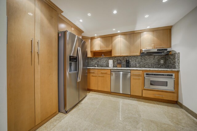 1865 Brickell Ave Unit A611, Miami, FL 33129 - kitchen featuring appliances with stainless steel finishes, under cabinet range hood, tasteful backsplash, light stone countertops, and recessed lighting