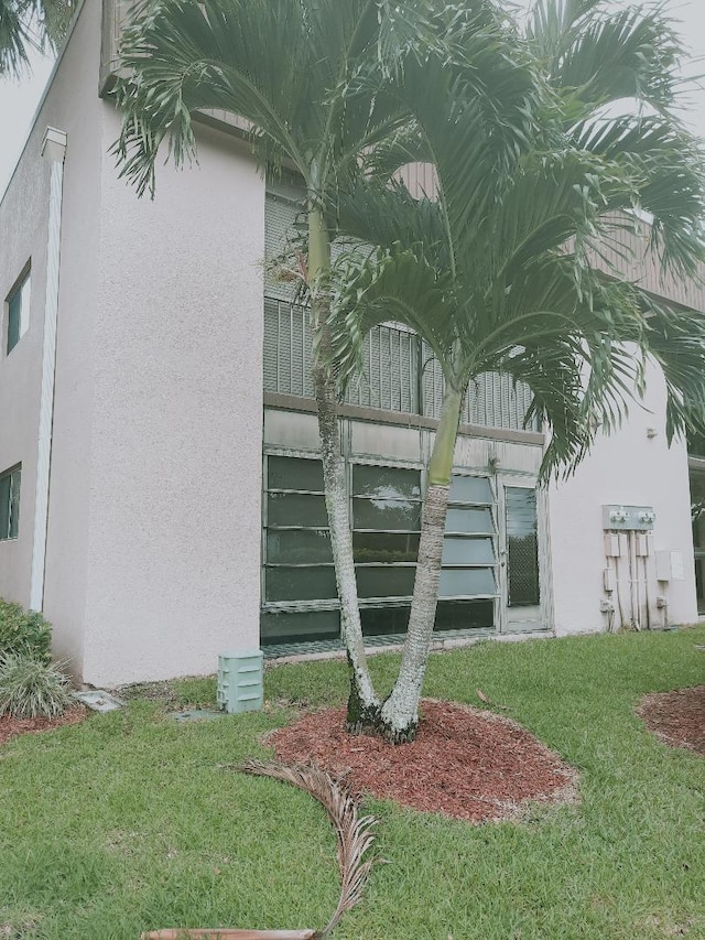 15109 Ashland Dr Unit 307, Delray Beach, FL 33484 - view of side of property featuring stucco siding and a lawn