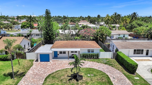 view of front of home featuring curved driveway, an attached garage, a residential view, and stucco siding