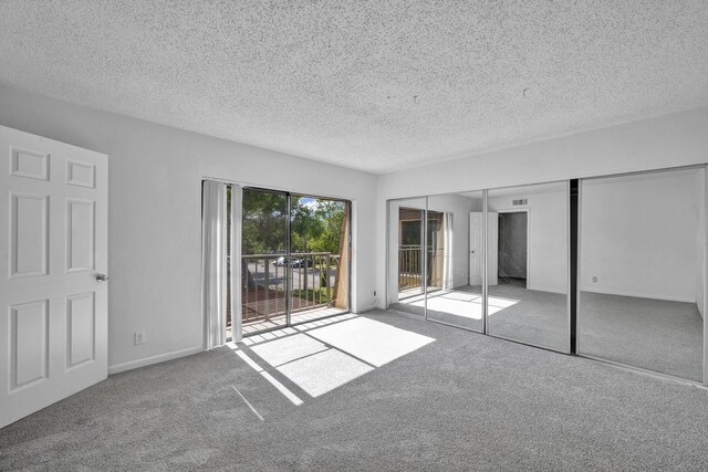 2660 Albatross Rd N Unit 6-C, Delray Beach, FL 33444 - unfurnished bedroom featuring access to exterior, carpet flooring, and a textured ceiling