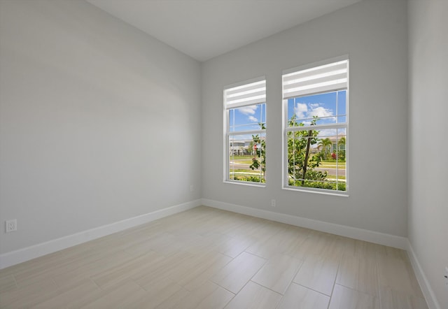 unfurnished room with healthy amount of natural light and baseboards