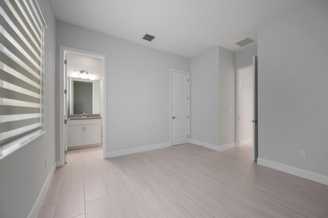unfurnished bedroom with baseboards and connected bathroom