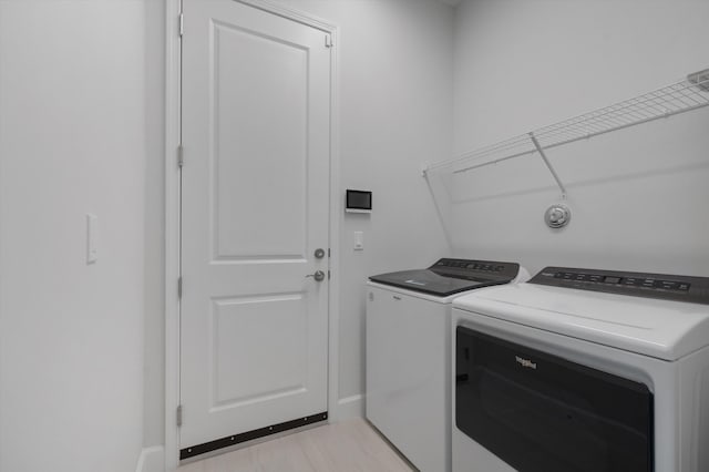 laundry area featuring washing machine and dryer and baseboards