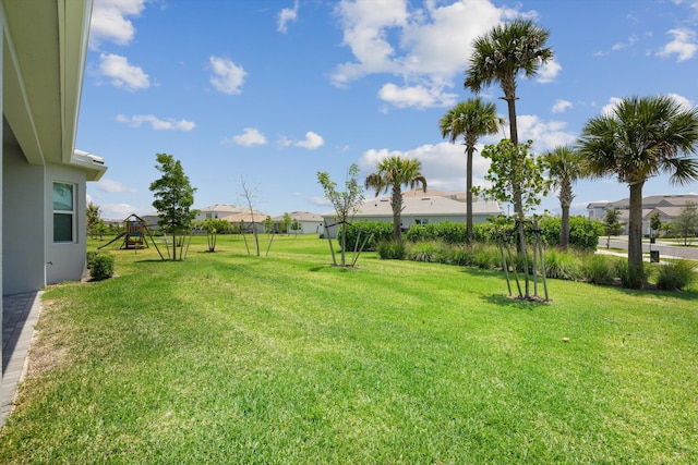 view of green lawn featuring a playground and a residential view