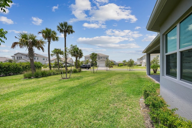 view of grassy yard featuring a residential view