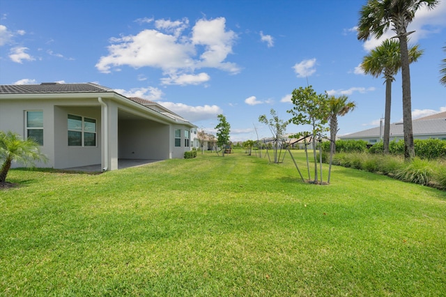 view of green lawn with a patio